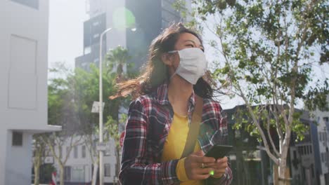 mujer de raza mixta con máscara médica de coronavirus en la calle