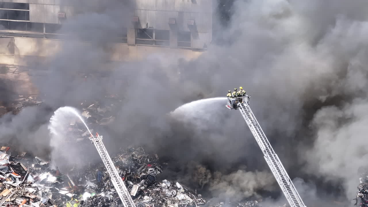 Riprese Aeree al Rallentatore di Vigili del Fuoco che Combattono un Grande Incendio di Rottami Metallici a Chattanooga, TN