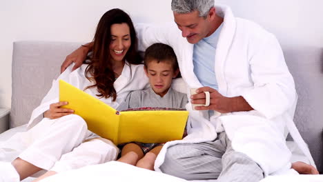 padres y su hijo leyendo un libro