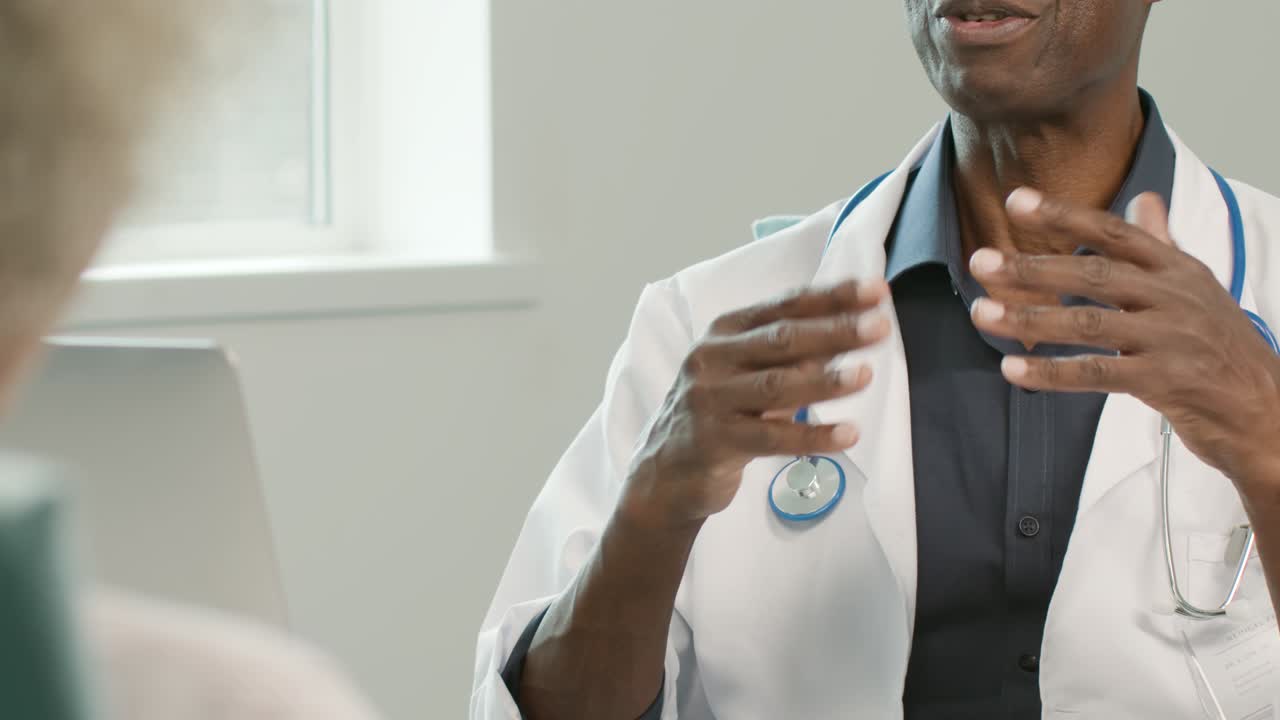 sección media médico de mediana edad moviendo las manos mientras habla con el paciente