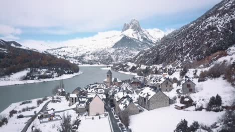 Un-Dron-Suave-Se-Aleja-De-Un-Pequeño-Pueblo-En-Medio-De-Los-Pirineos