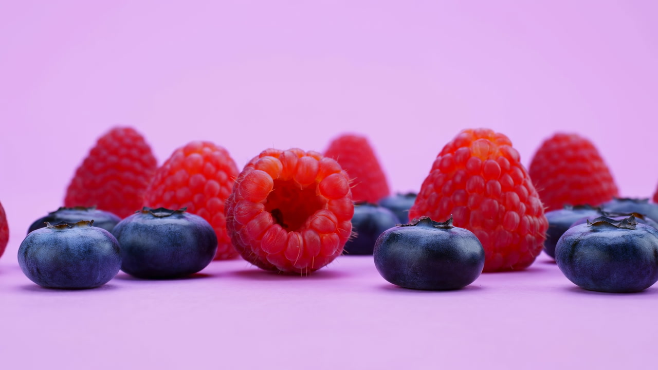 Fresh Raspberries And Blueberries On Pink Backdrop In Closeup Row, Vivid Color Contrast, Glossy Texture,