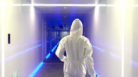 scientist researchers and technicians in a coverall conducting a research, walking through modern laboratory. people with science concept.
