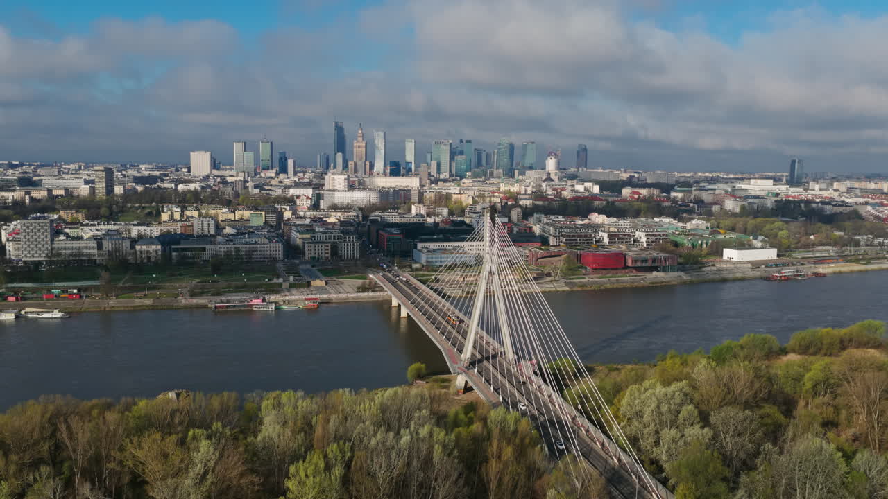 Vista diurna del Ponte Swietokrzyski sul fiume Vistola con lo skyline di Varsavia, Polonia, sullo sfondo. Ripresa laterale con drone