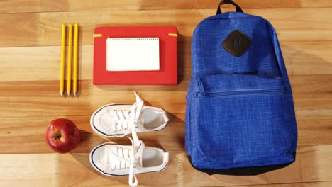 primer plano de la bolsa de la escuela con zapatos y manzana