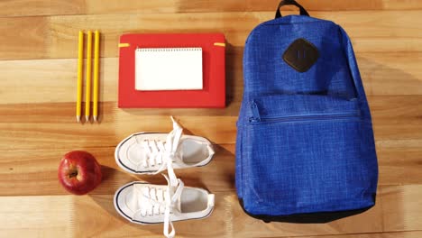 close-up of school bag with shoes and apple