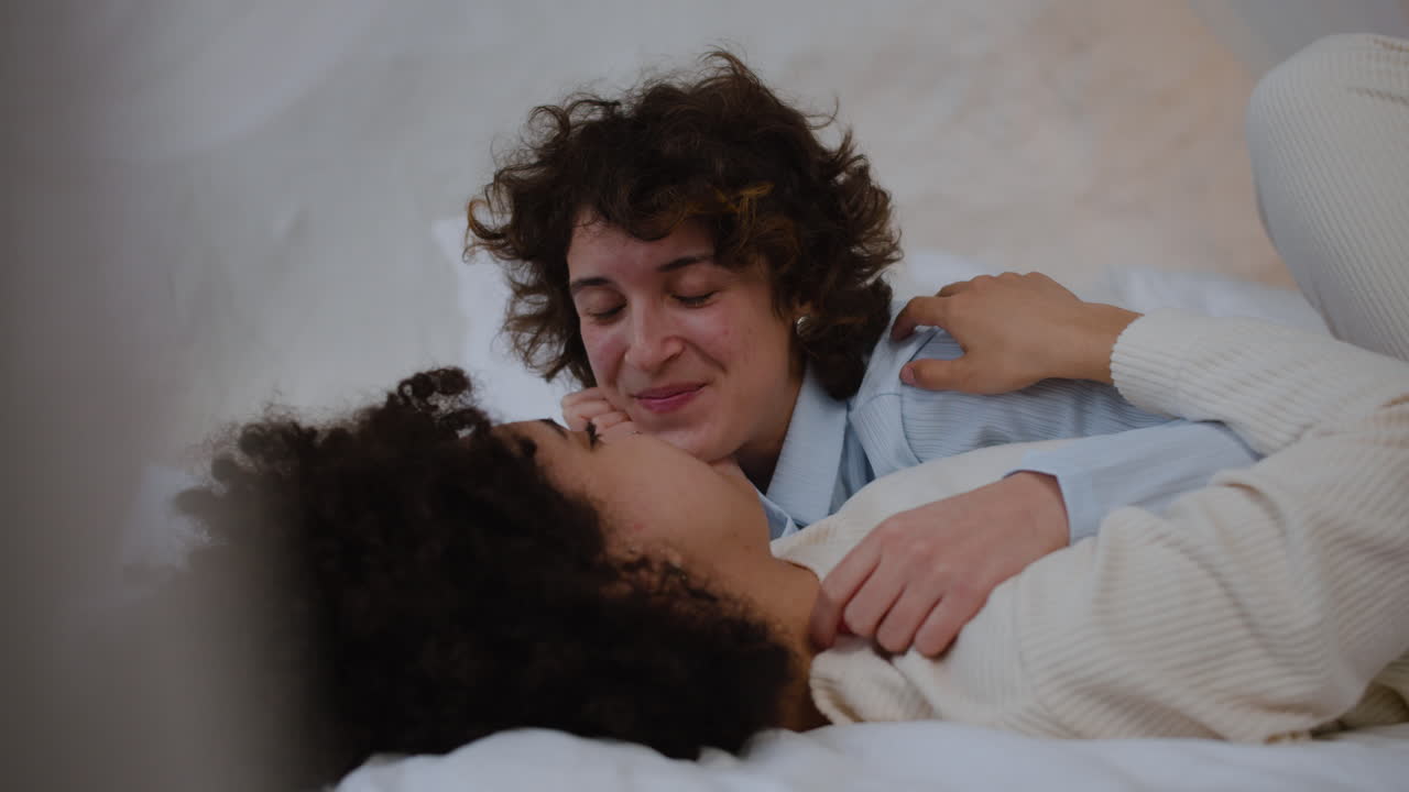una pareja feliz hablando en la cama.