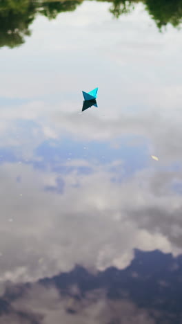 paper boat on the river. paper boat sailing along the river. vertical video