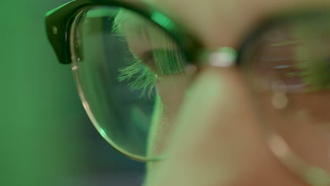 Extreme-close-up-caucasian-eye-caucasian-hacker-man-in-green-setting