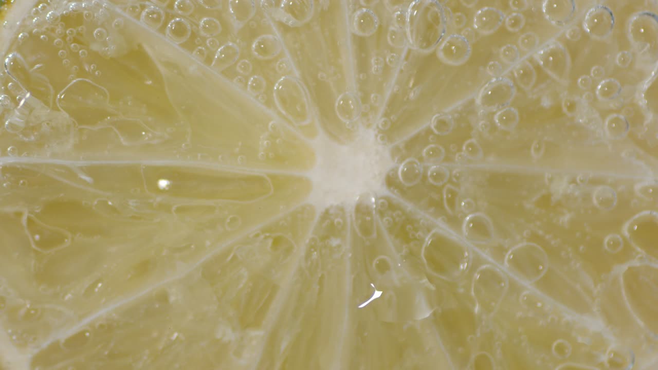 공기 거품이 있는 물 아래의 신선한 라임 한 조각.