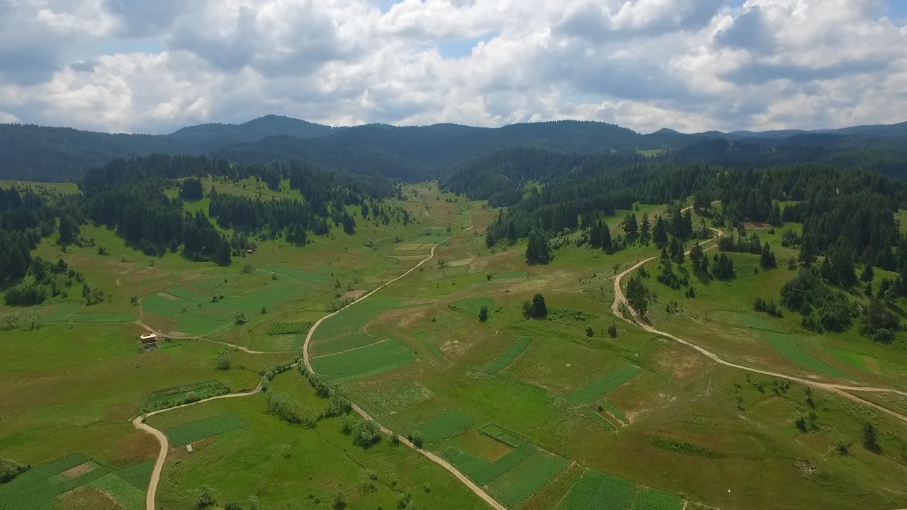 camino estrecho en una zona montañosa, rodeado de tierra cultivable