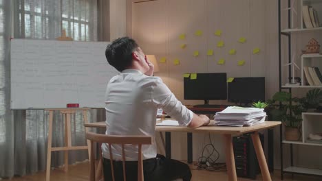 사무실에서 문서와 함께 열심히 일하는 동안 잠자리에 들기 전에 는 아시아 남자의 뒷면