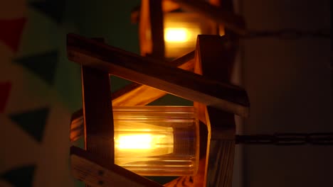 close-up of a warm glowing edison bulb in a wooden lamp