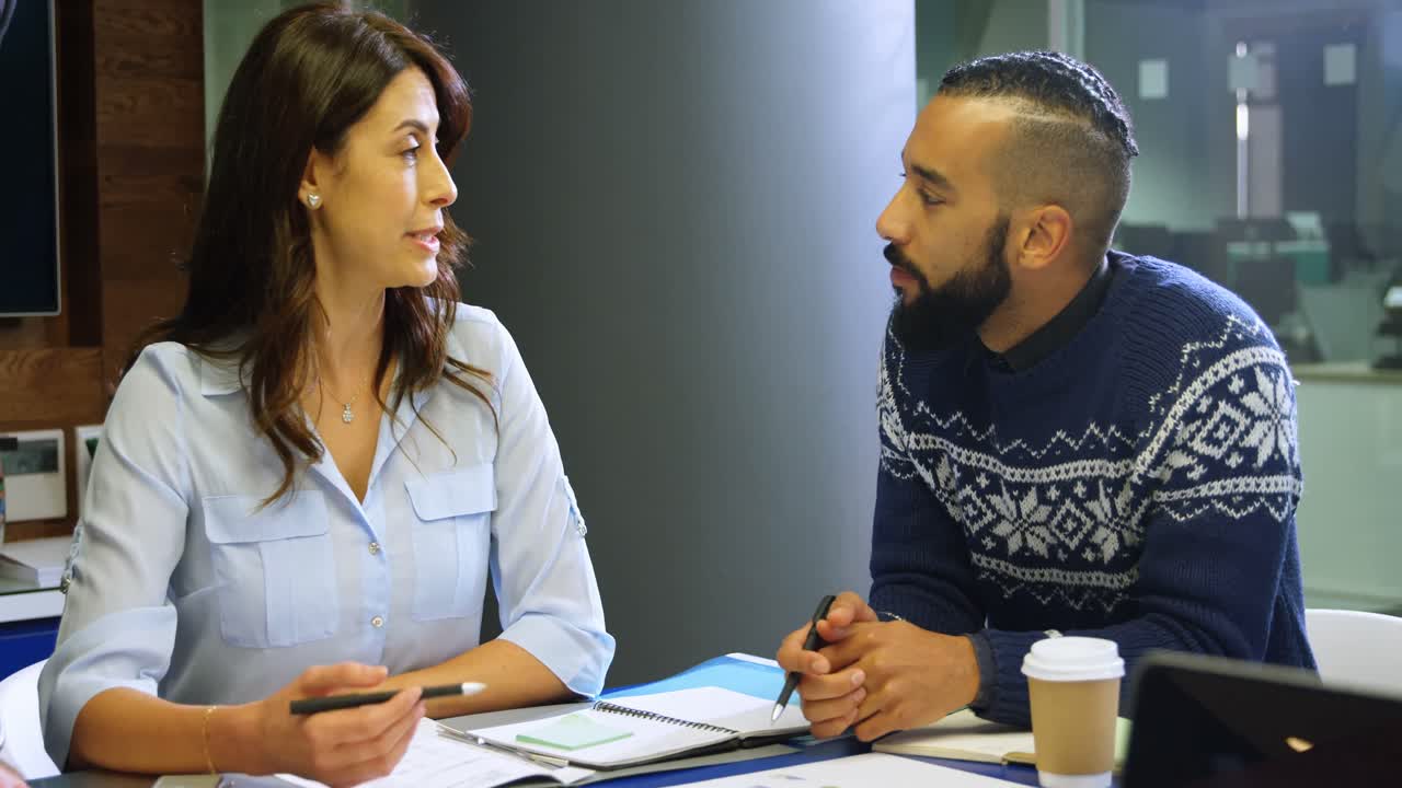 Executives discussing on documents in conference room 4k