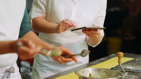 male and female baker putting ingredients on pasta dough 4k