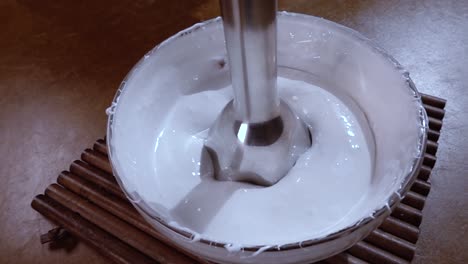 beaten eggs with sugar using a mixer. slow motion with rotation tracking shot.