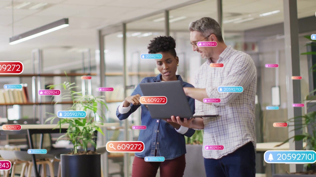 Vertical video: Man pointing, pair reviewing laptop while data widgets floating, confirming metrics
