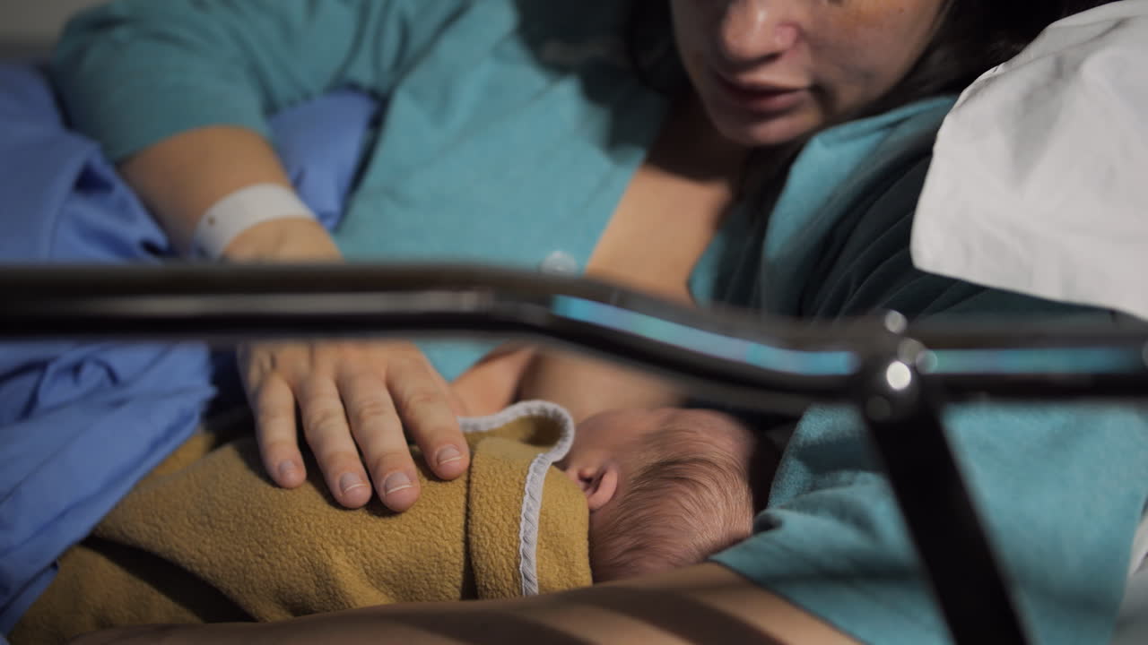 Mother breastfeeding newborn infant baby after labor