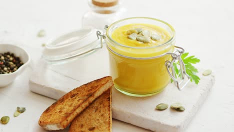 pumpkin soup in glass jar with bread