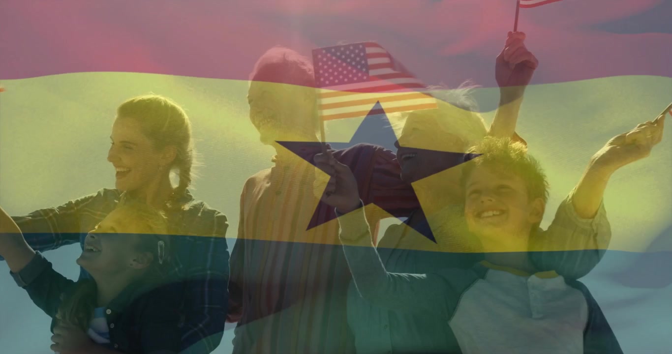 Family waving US flags after adult lifting child, sheer flag rippling across frame for marketing