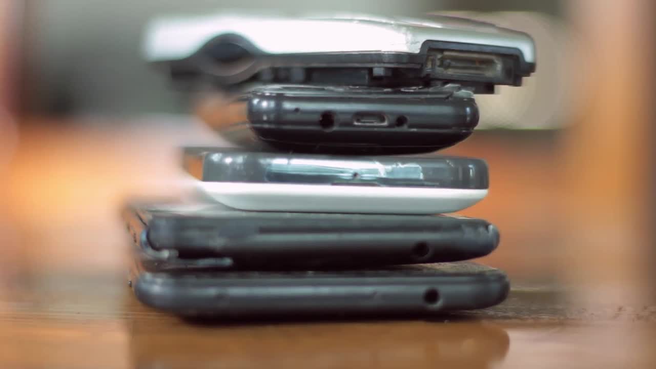 old mobile phones piled up on a table no people stock video stock footage