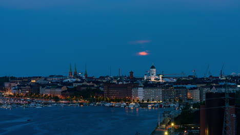 timelapse de una puesta de luna parcialmente nublada sobre el paisaje urbano de kruununhaka en helsinki