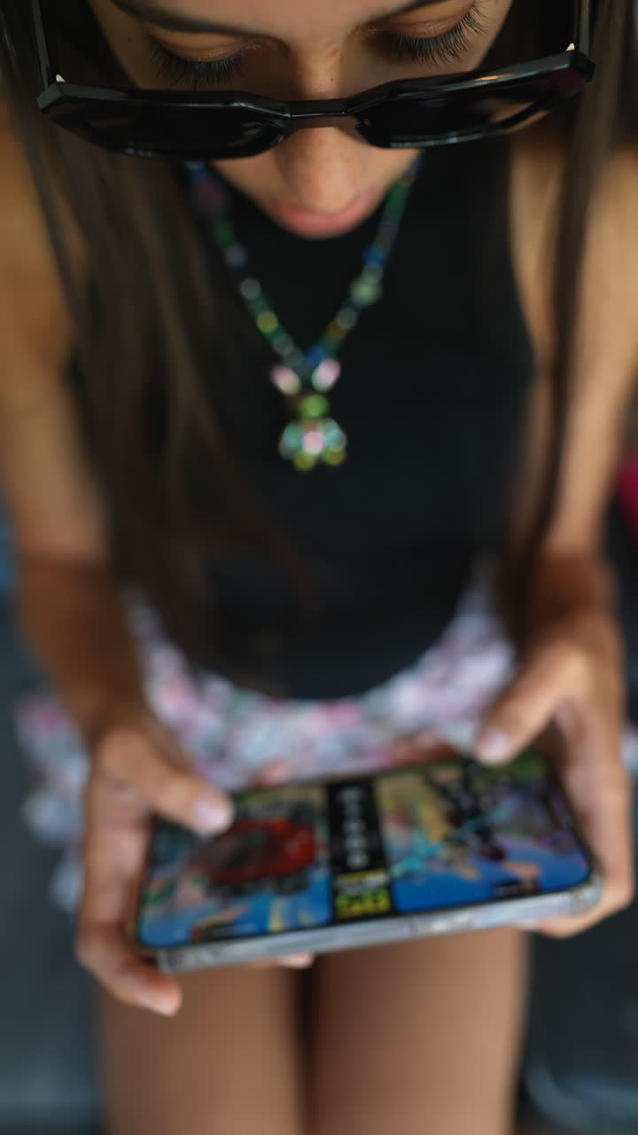 una adolescente jugando a videojuegos en su teléfono inteligente