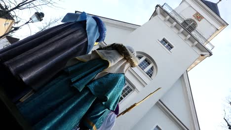 Carolers-stand-in-front-of-a-church-and-wait