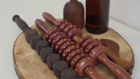 set of wooden tools with different types of rollers, cup, paddles and oil for wood therapy