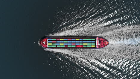 aerial view of a cargo ship with containers moving through water