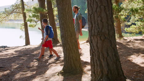 fathers with sons on hiking adventure through woods