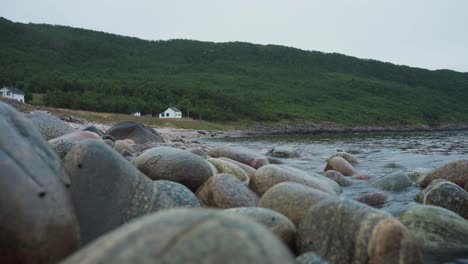 close up of rocky river with fresh water and green mountain