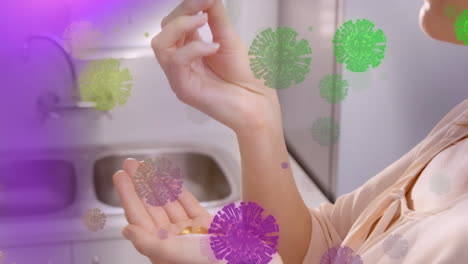 animación de coloridas células de covid-19 flotantes sobre una mujer caucásica que toma píldoras en casa