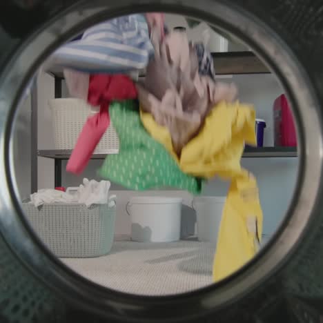 Woman-throws-laundry-for-washing-near-washing-machine