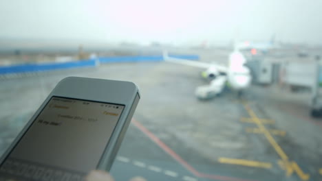 escribir mensajes de texto en el teléfono inteligente en el aeropuerto