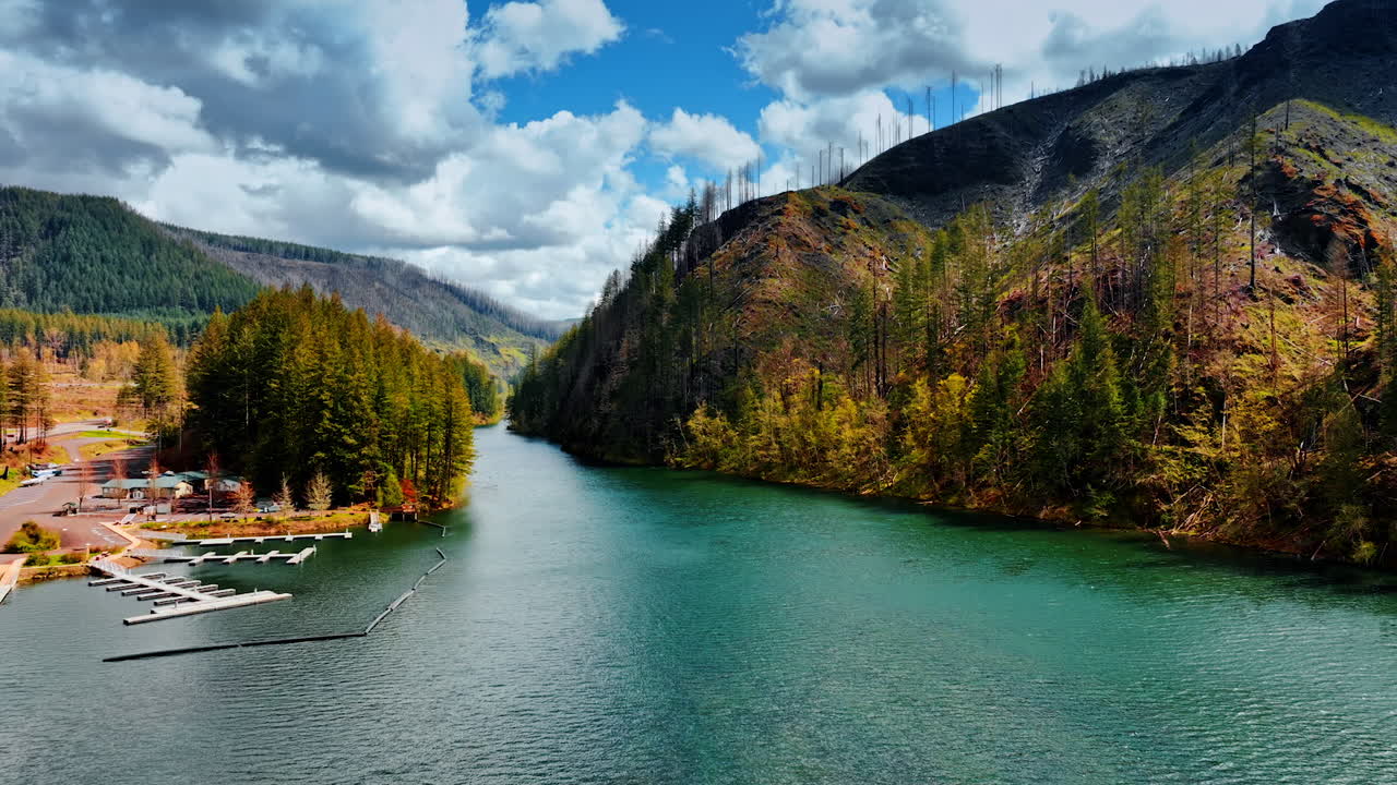 Beautiful sea-green water in the river at the foot of the mountain. Empty pier on the river for boats and rafting activities. Top view. Oregon State, USA.