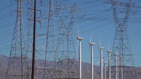 turbinas de viento giran en el desierto cerca de líneas eléctricas y postes desierto de mojave palm springs california