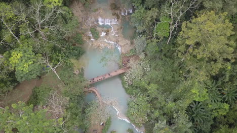 Tourists-enjoy-beauty-of-Kuang-Si-tired-waterfall-in-Laos,-SE-Asia