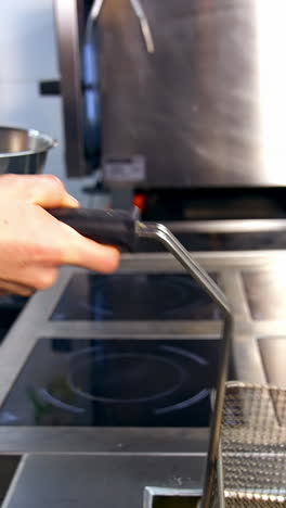 preparando papas fritas en una cocina comercial