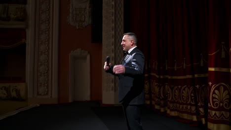 actor steps on classic theater stage. man in suit is walking in spotlights during the performance. classic theater concept.
