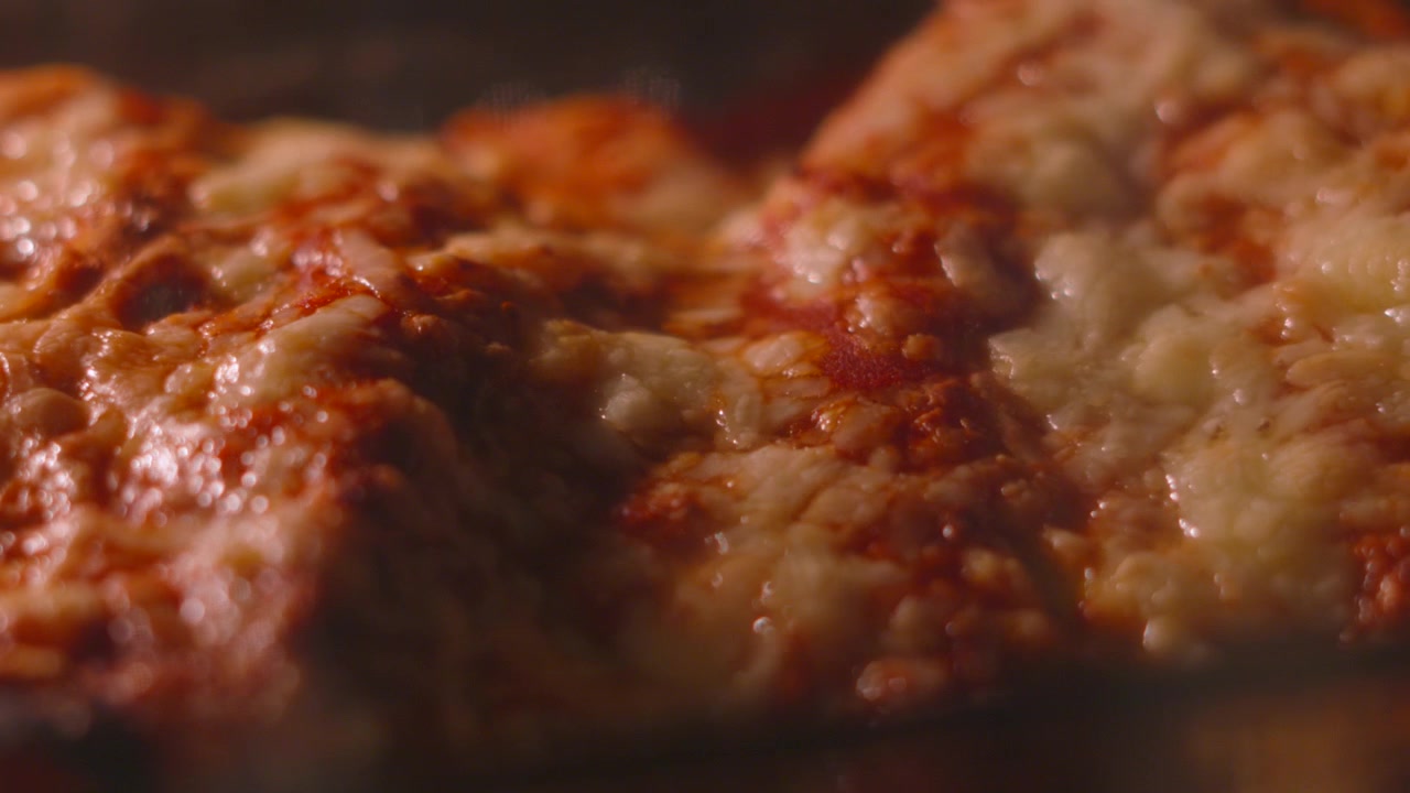 Primo piano di enchiladas messicane piccanti con formaggio che bolle e si scioglie in un forno caldo mentre la telecamera si muove elegantemente. Videografia alimentare di alta qualità. 4K.
