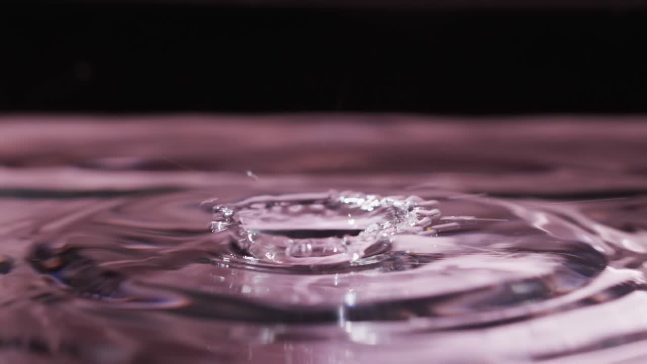 video de primer plano de gotas de agua con espacio de copia en fondo rosa