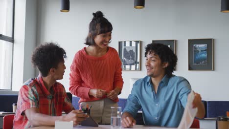 Happy-diverse-business-people-discussing-work-during-meeting-at-office