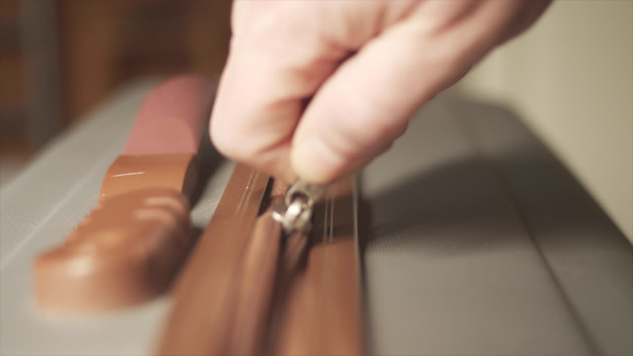 maleta gris con cremallera a mano cerrada, enfoque selectivo de primer plano