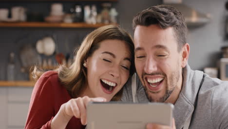 pareja joven atractiva en casa riéndose de bromas divertidas de internet en línea usando una tableta digital
