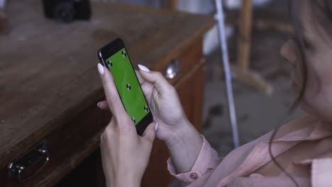 mujer usando un teléfono con pantalla verde