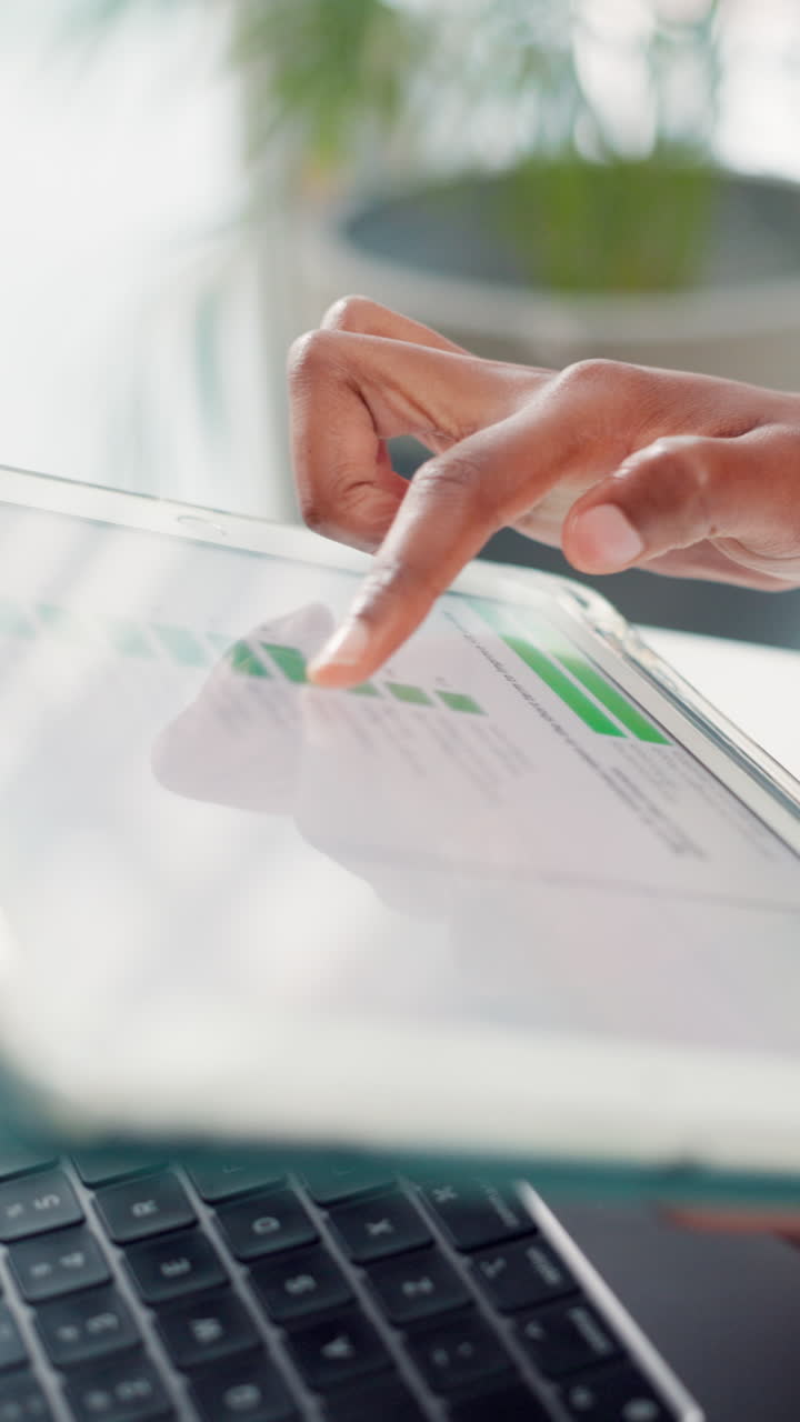 Close Up of Hand Tapping on Digital Tablet Screen with Business Charts