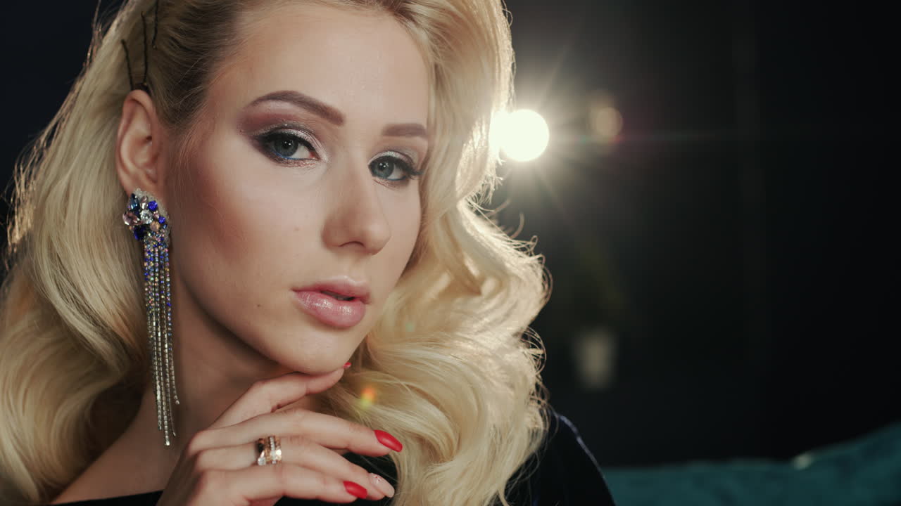 Ritratto di una giovane donna attraente sullo sfondo di luci sfocate di decorazioni natalizie 1