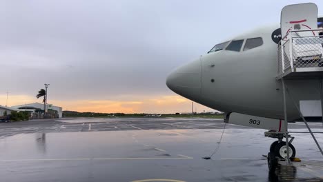 avión en el aeropuerto durante la puesta o el amanecer con lluvia
