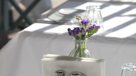 beautiful purple flowers in a glass vase on a table setting